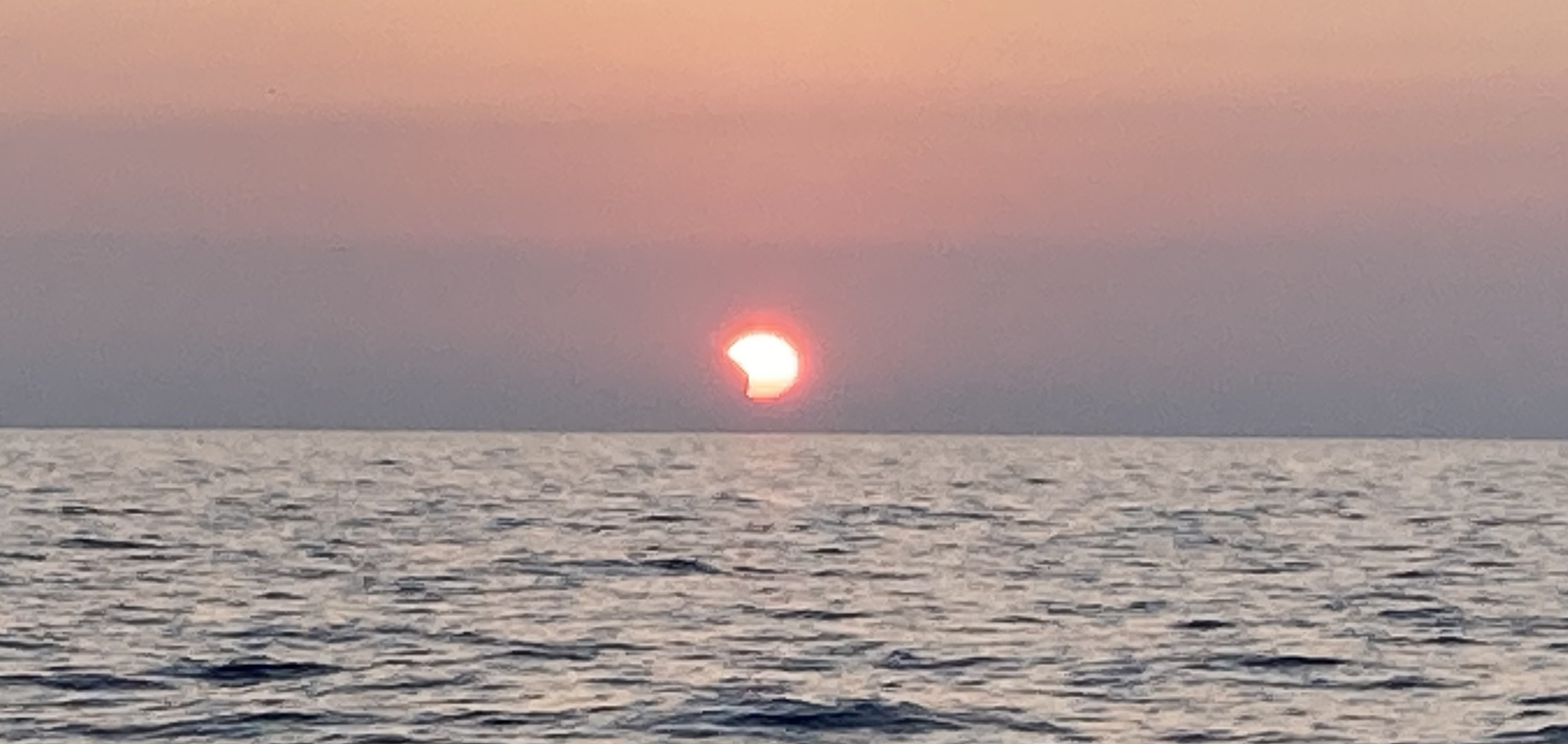 Partial eclipse at sunrise over Lake Michigan